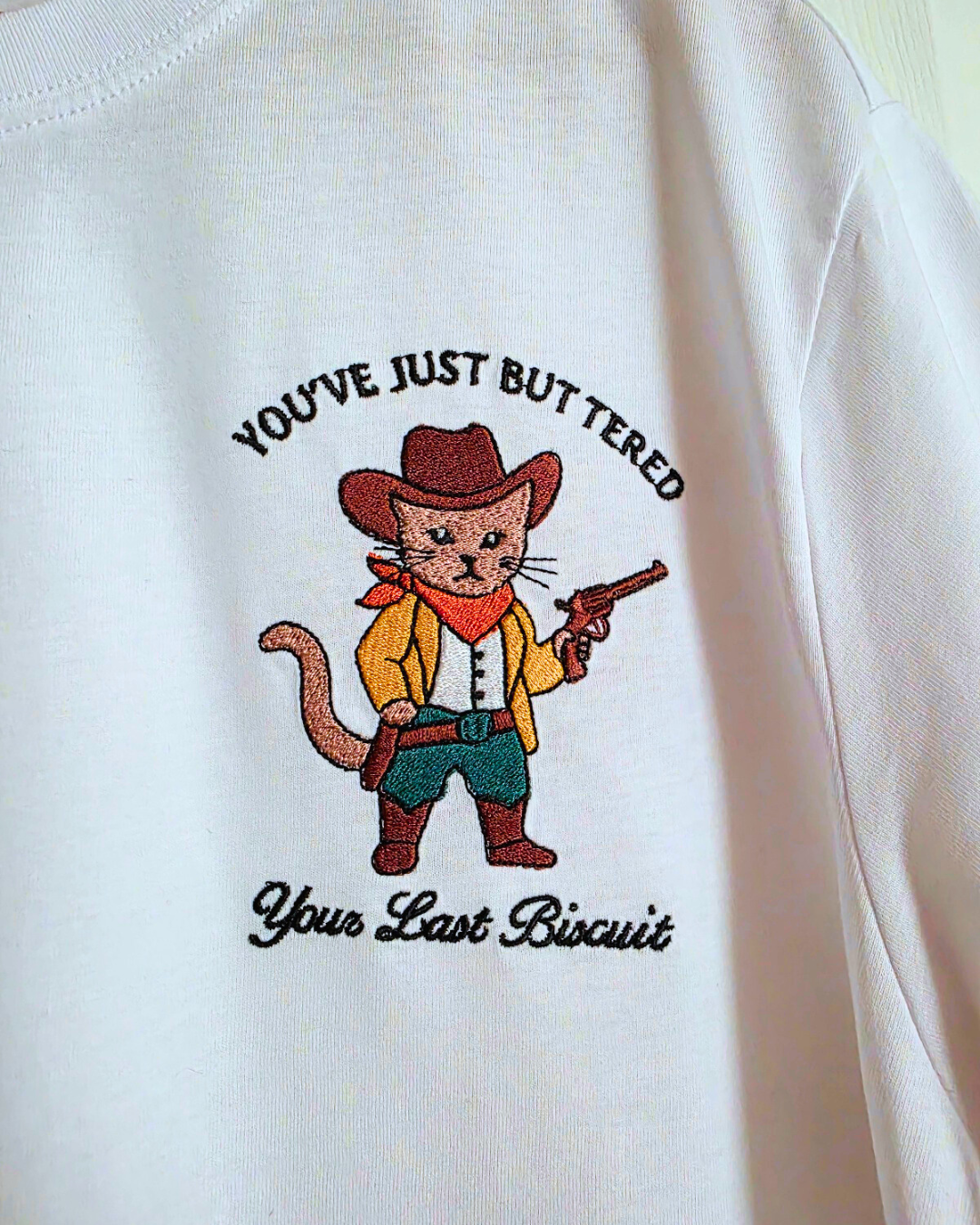 "You've just buttered your last biscuit" - cowboy cat embroidered t-shirt